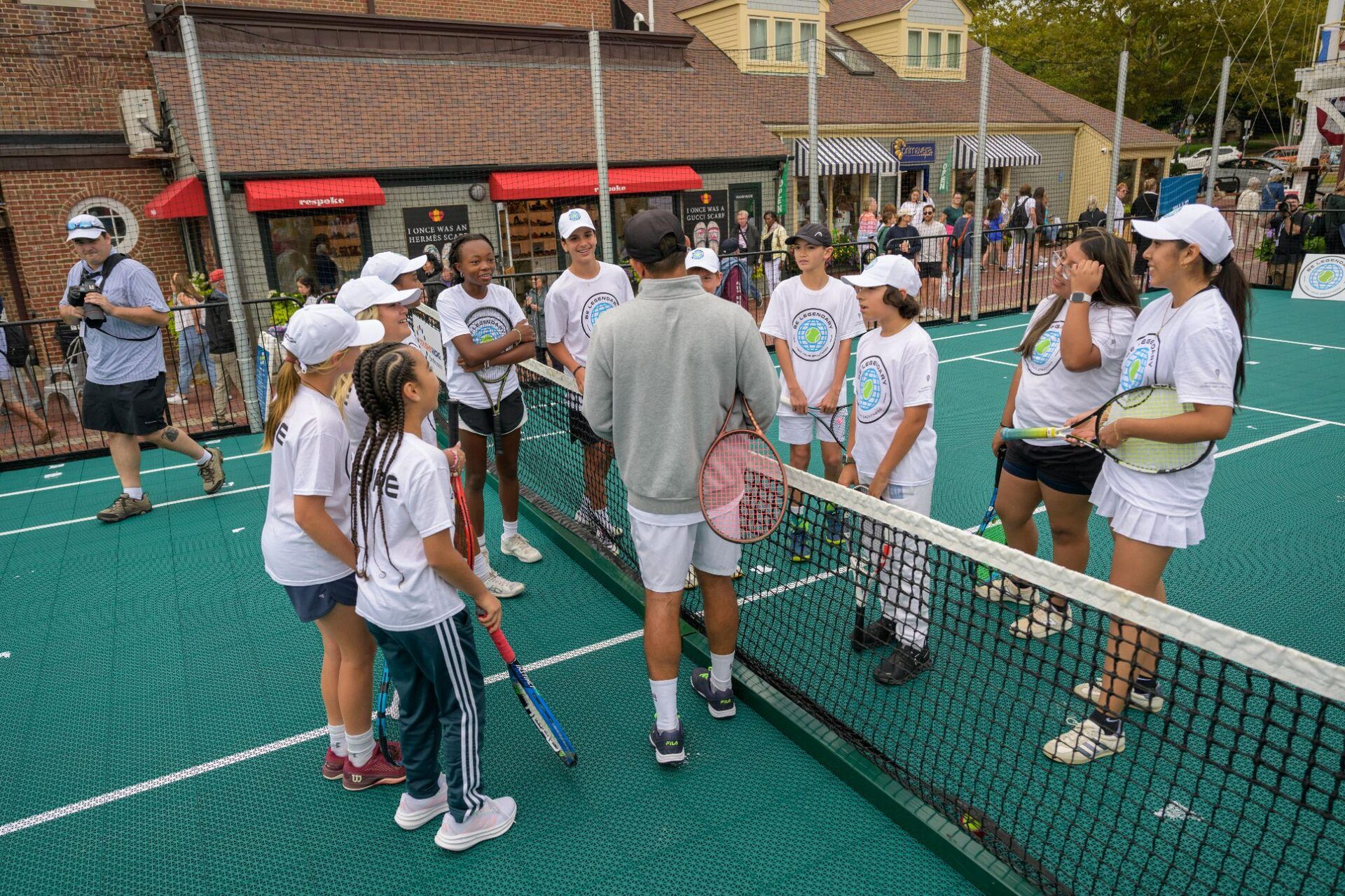 Be Legendary participants gather at the net with a Hall of Famer on the courts in Newport