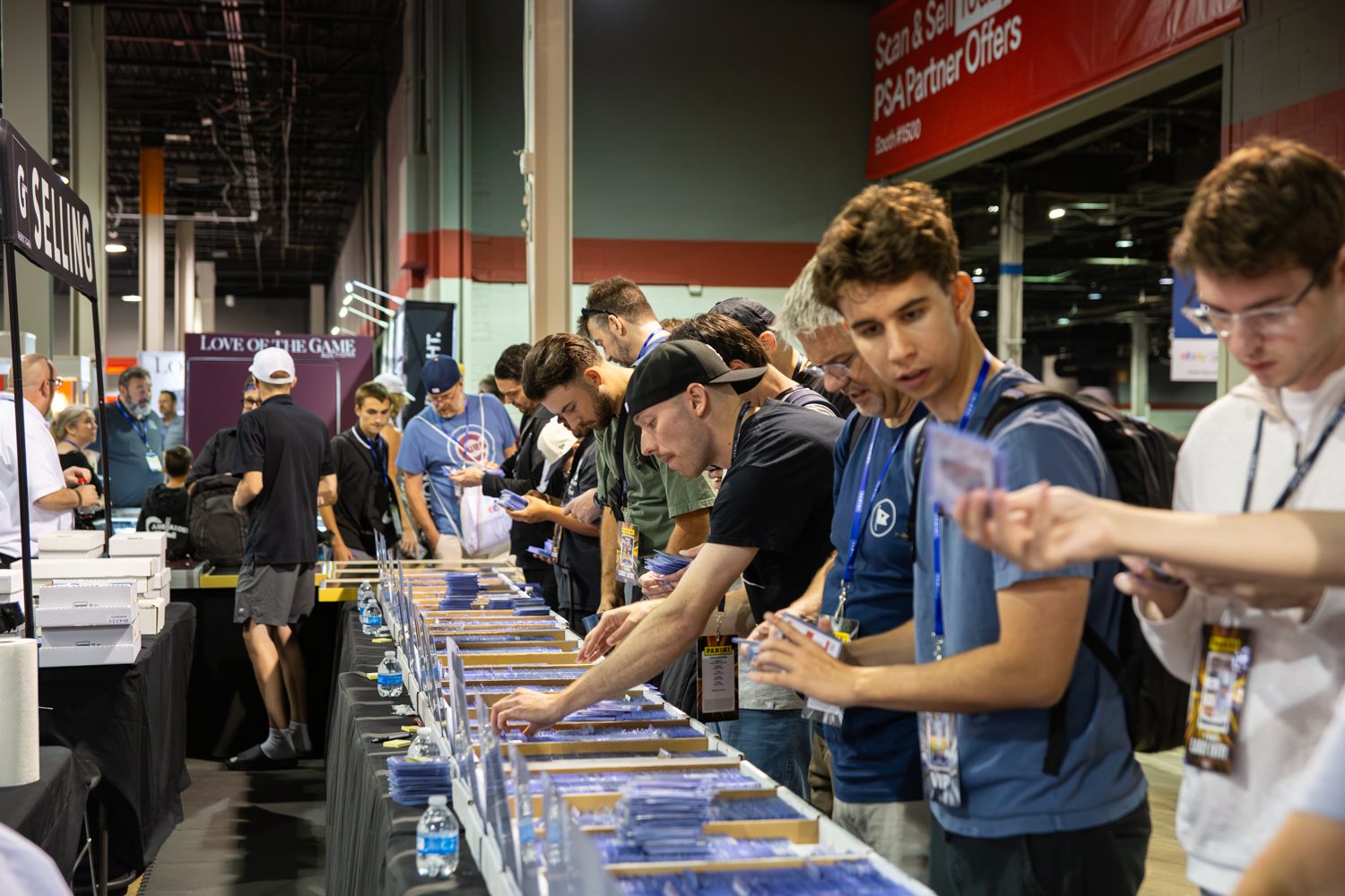 Collectors browsing card boxes on the show floor at the National Sports Collectors Convention